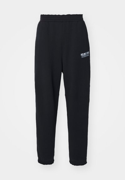 Sorte sweatpants lavet af blød stof, med en strækbar talje, indsnævrede ben og et lille hvidt logo på venstre side.