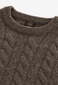 Maglione marrone in lana con un motivo a diamante testurizzato e collo a coste. Presenta un'etichetta che indica "Durable Goods." Aspetto morbido e caldo.
