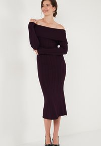 Vestito midi off-the-shoulder in profondi tonalità di viola, con maniche lunghe, silhouette aderente e una texture liscia e elastica.