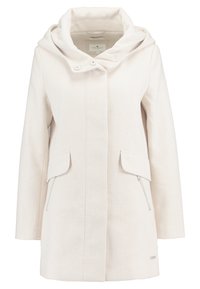 Ljus krämfärgad kappa med en strukturerad finish, en stor huva, två framfickor, en sidficka med dragkedja och en rak skärning.