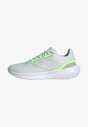 Baskets de sport gris clair avec semelle blanche, dessus en mesh, marquage discret à trois bandes et accents vert néon près des lacets et du talon.