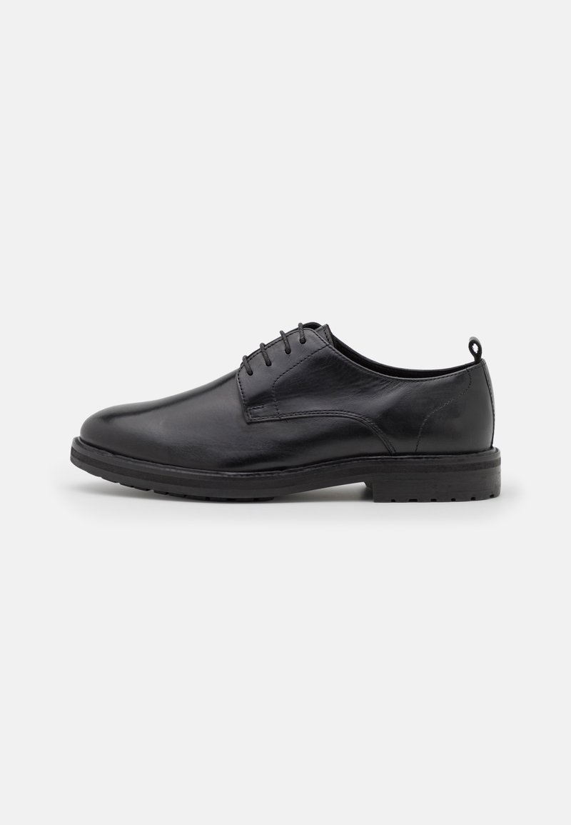 Chaussure habillée pour homme en cuir noir à lacets, bout arrondi et talon bas, vue de profil sur fond blanc.