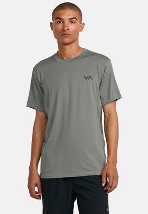 Kortærmet athleticsk t-shirt i gråt materiale, med rund hals og et lille sort logo på venstre bryst. Glat, let tekstur.