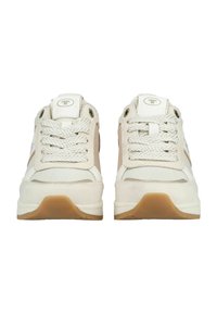 Pár bílých a béžových tenisek s texturovanými tkaničkami, zaoblenou špičkou a gumovými podrážkami, pohled zepředu.