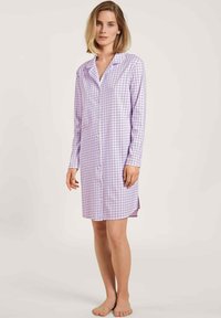 Lange nachthemd in lichtpaars en wit geruite patroon, met knopen aan de voorkant en zijsplitten aan de zoom. Zachte stof.