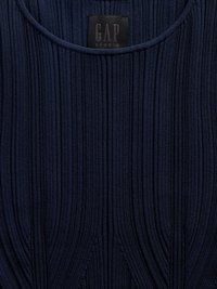Ναυτικό μπλε ριγωτό ύφασμα με κάθετες γραμμές και στρογγυλή λαιμόκοψη, με μια μαύρη ετικέτα που γράφει «GAP STUDIO» στο εσωτερικό του λαιμού.