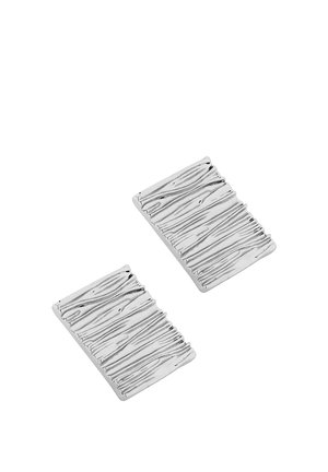 Dve pravokotni srebrni uhani z teksturiranimi, nepravilnimi horizontalnimi žlebovi, ki spominjajo na lesni vzorec.