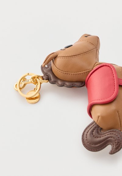 Δερμάτινο μπρελόκ σε σχήμα σκύλου με κόκκινο κολάρο, καφέ ουρά, ραμμένα χαρακτηριστικά προσώπου και χρυσό μεταλλικό κρίκο και κούμπωμα.