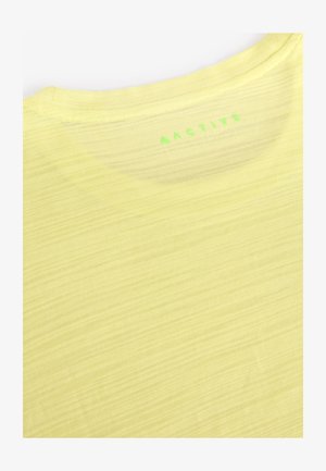 T-shirt d'athlétisme jaune citron, tissu léger avec une texture subtile, doté d'un col rond et du mot « ACTIVE » imprimé en vert dans le dos.