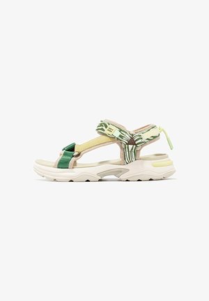 Sandal deportivo que cuenta con una mezcla de correas de tela verde y amarilla con un acento estampado, suela acolchada y una entresuela beige.
