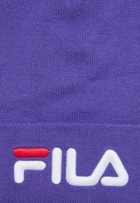 Fioletowa dziana czapka z miękką teksturą, z białym i czerwonym haftowanym logo "FILA" z przodu.