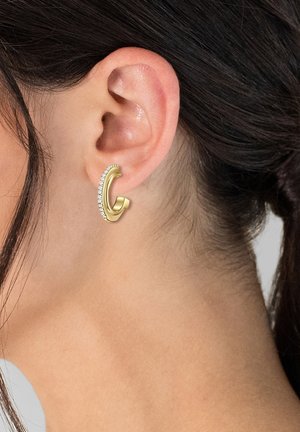 Guld hoops ørering med et buet design, der har en række små klare sten langs den ydre kant, båret på øret.