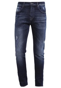 Jeans en denim bleu foncé avec une coupe slim, arborant un aspect délavé, un léger effet vieilli sur les cuisses et un design classique à cinq poches.