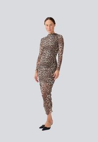 Robe à manches longues en imprimé léopard avec une silhouette cintrée, fabriquée dans un tissu extensible, présentant des détails froncés et un col montant.