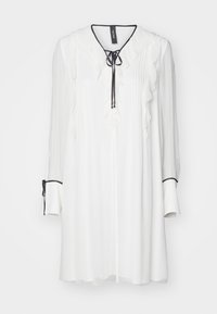 Weißes Bluse mit gerüschter Vorderseite, langen Ärmeln und einer Bindekrawatte am Hals. Verfügt über schwarze Akzente an den Ärmelbündchen und eine sanft plissierte Textur.