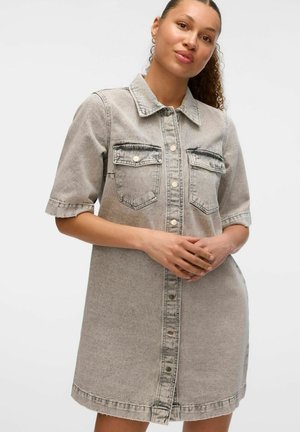 Siva jeans srajčna obleka s kratkimi rokavi, sprednjimi gumbi, dvema žepoma na prsih in oskrbljenim robom. Ima klasičen ovratnik in sproščen kroj.