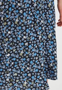 Blumenkleid mit schwarzem Hintergrund und blauen, weißen und grünen Blumen, aus leichtem Stoff mit fließendem Design und Knöpfen.