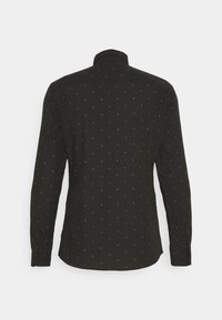 Chemise noire à manches longues avec un motif discret de petits points multicolores, des poignets boutonnés et un col classique vue de dos.