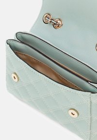 Lichtblauwe doorgestikte leren handtas met gouden beslag, voorzien van twee vakken en een gladde beige voering.