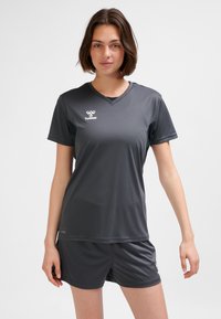 Mörkgrå atletisk outfit bestående av en kortärmad V-ringad tröja och shorts, gjord av mjukt, fukttransporterande tyg, med en logotyp på tröjan.