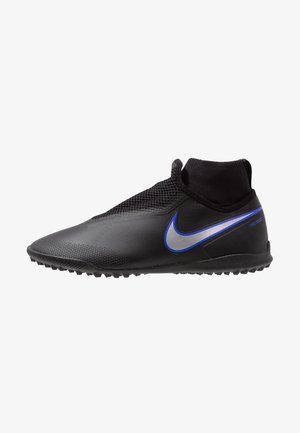 Chaussure de sport noire à coupe mi-haute avec tige texturée, logo Swoosh bleu et argenté, et semelle cloutée pour les sports sur gazon synthétique.