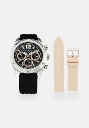Montre avec bracelet en caoutchouc noir, boîtier en acier inoxydable argenté, cadran noir texturé et sous-cadrans chronographes beiges. Comprend un bracelet supplémentaire beige.