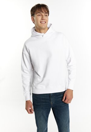 Witte hoodie met een voorkantalzak, ribgebreide manchetten en halslijn. Draagt met blauwe spijkerbroeken. Minimalistisch logo op de borst.