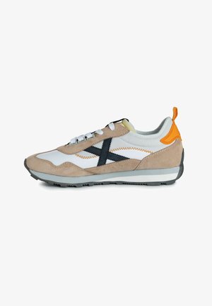Zapatillas de ante beige y malla blanca con acentos negros, lengüeta en naranja y suela gris. Presenta costuras de contraste y seis ojales para los cordones.