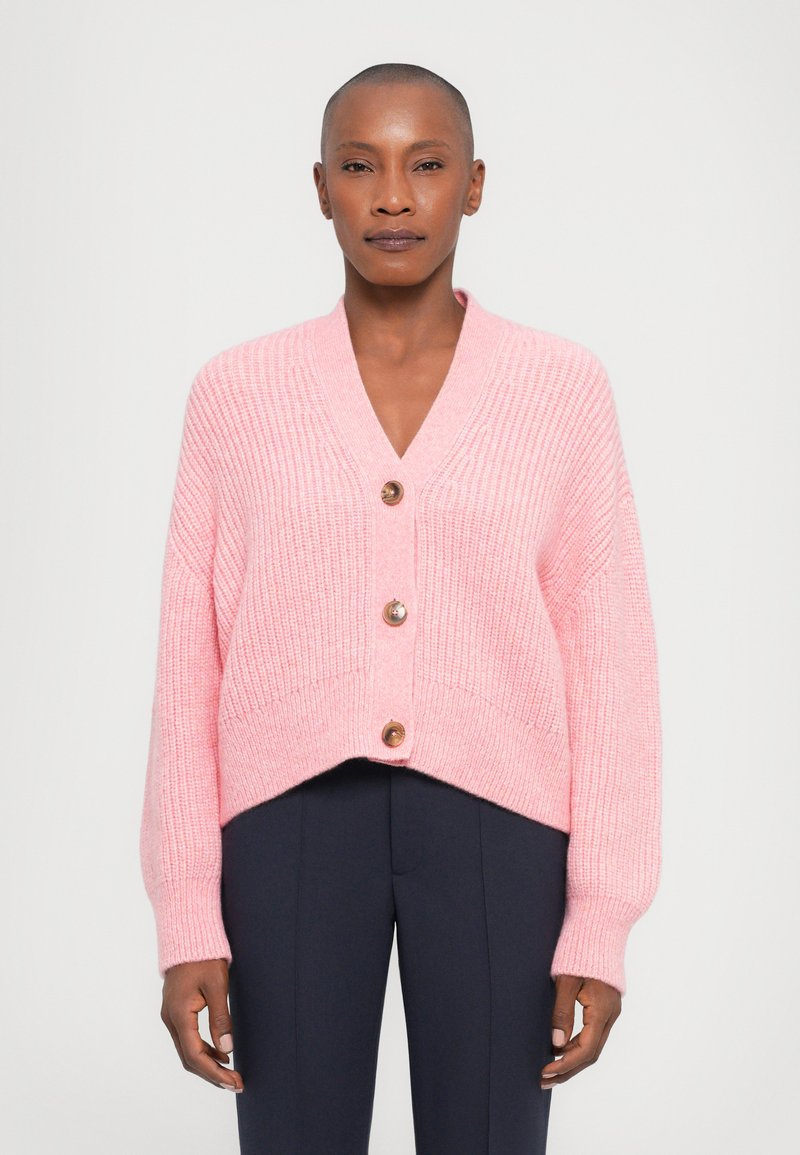 Rosa gestrickte Strickjacke mit V-Ausschnitt, kurz geschnittenem Design und langen Ärmeln, versehen mit drei braunen Knöpfen auf der Vorderseite.