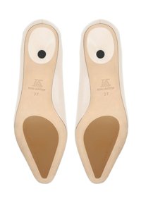 Paire de chaussures en cuir beige à bout pointu vue de la semelle, taille 37, avec des patchs antidérapants marron clair et des détails noirs circulaires au talon.