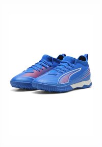 Blaue Sportschuhe mit einem eleganten Design, strukturiertem Material, Schnürverschluss und weißen Akzenten. Bietet auffällige Markenkennzeichnung in kontrastierenden Farben.