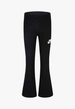 Leggings acampanados negros hechos de una tela elástica, con una cinturilla alta y un logo de Nike blanco en el lado izquierdo.