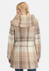 Wollener Karopelz in Beige, Creme und Braun mit einem breiten Kragen, der ein kariertes Muster zeigt und eine lockere Passform hat.