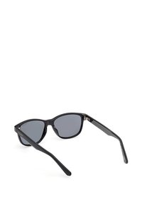 Svarta solglasögon med grå linser, kattögd form, texturerade bågar och metallaccent. Designade för en strömlinjeformad, modern look.