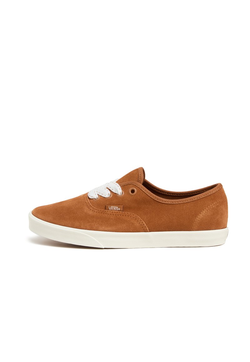 Baskets en suede marron avec lacets blancs, semelle en caoutchouc, design bas et logo Vans sur le côté. Texture lisse et style classique.