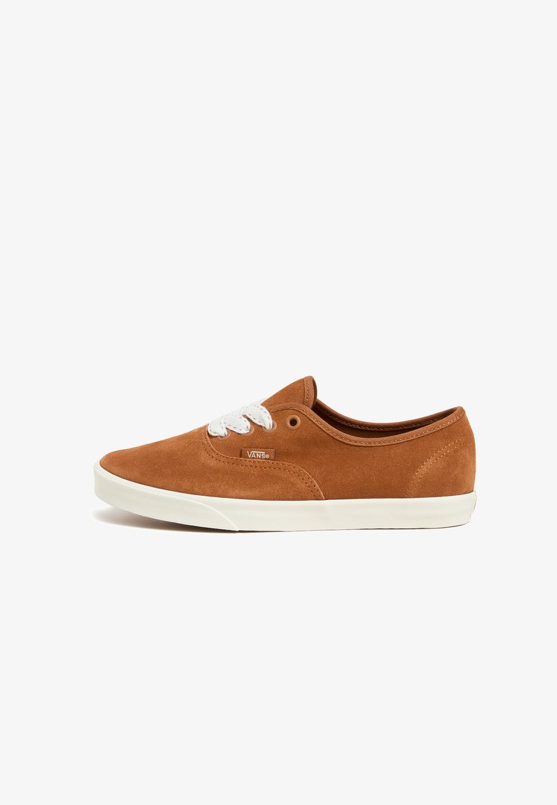 Baskets en suede marron avec lacets blancs, semelle en caoutchouc, design bas et logo Vans sur le côté. Texture lisse et style classique.