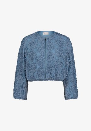 Veste courte en tissu bleu clair avec applications florales texturées, manches longues, et fermeture éclair à l'avant. Présente un col rond.