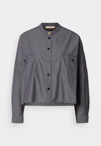 Korte shirt van donkergrijze stof met verticale strepen. Heeft een staande kraag, knoopsluiting en twee borstzakken met klep.