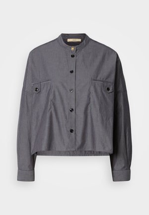 Camisa recortada en tela gris oscuro con rayas verticales. Cuenta con un collar alzado, cierre de botones y dos bolsillos en el pecho con solapa.