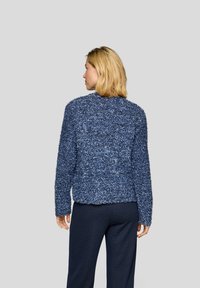 Marineblaues, flauschig strukturiertes Sweatshirt mit rundem Hals und langen Ärmeln, das eine lockere Passform und keine sichtbaren Verschlüsse hat. Rückansicht gezeigt.