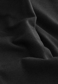 Tissu noir avec une texture lisse et mate, affichant des plis et des rides subtils, indiquant douceur et flexibilité.