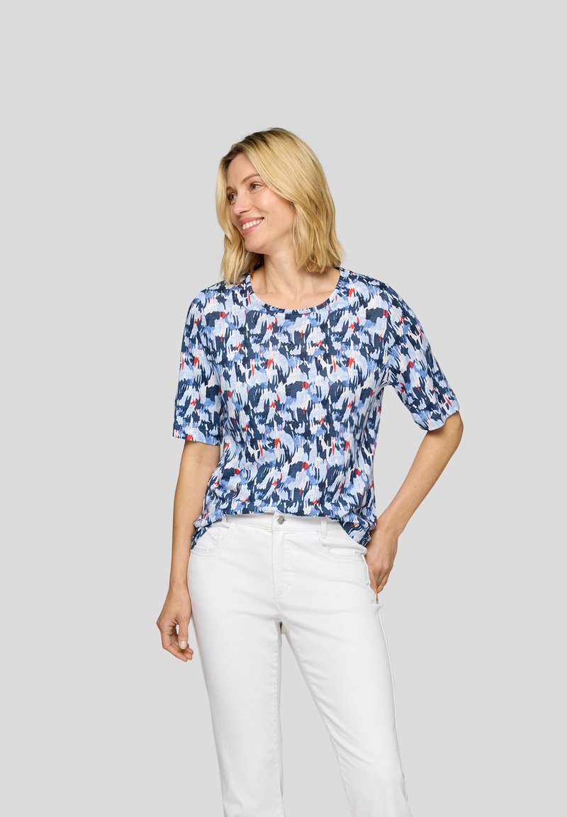 Short-sleeve top in a blue patterned fabric, featuring abstract shapes in light blue, red, and navy. Relaxed fit with a round neckline.