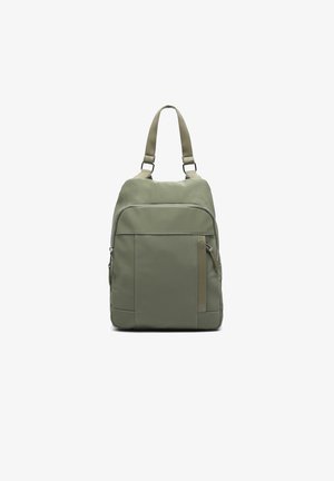 Mochila verde oliva con una textura suave, que cuenta con un bolsillo frontal con cremallera y correas ajustables. Diseño simple y rectangular con acentos sutiles.