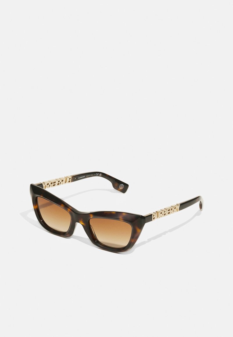 Kilpkonnakoorega prillid, millel on kassi silmade kuju ja gradueeritud pruunid objektiivid. Õlavarre peal on kuldse tooni "Burberry" brändi logo.