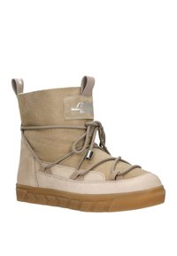 Bottines en cuir nubuck beige et cuir avec semelle en caoutchouc, dotées d'un col rembourré, d'un laçage sur le devant et de doubles tirettes pour un enfilage facile.