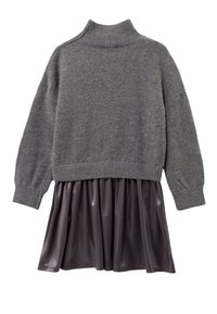 Maglione grigio con colletto alto e maniche lunghe, abbinato a una gonna plissettata lucida di un viola scuro. Tessuto a maglia morbido nella parte superiore.