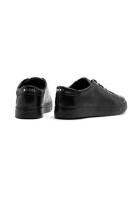 Sneaker nere in pelle con finitura liscia. Le caratteristiche includono un profilo basso, punta rotonda, design con lacci e logo impresso sul tallone.