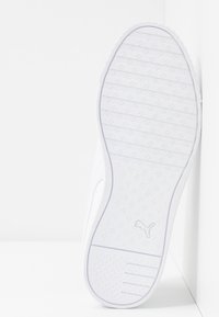 Bílá podrážka tenisky s texturovaným grip vzorem, obsahující vodorovné pruhy a vyražené logo. Hladký horní okraj a zakulacený design špičky.