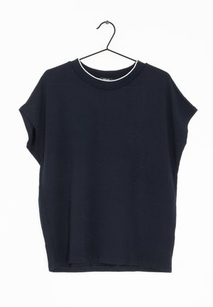 Zwart T-shirt met korte mouwen en ronde hals, hangend aan een dunne zwarte draadhanger tegen een witte achtergrond.