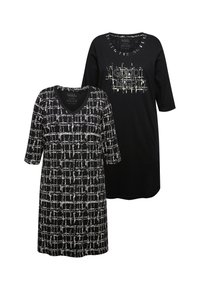 Tunika w czarno-białe wzory, jedna z dekoltem w serek i wzorem w kratkę, druga w jednolitym czarnym kolorze z napisem "Dobranoc". Obie mają rękawy o długości trzech ćwiartek.